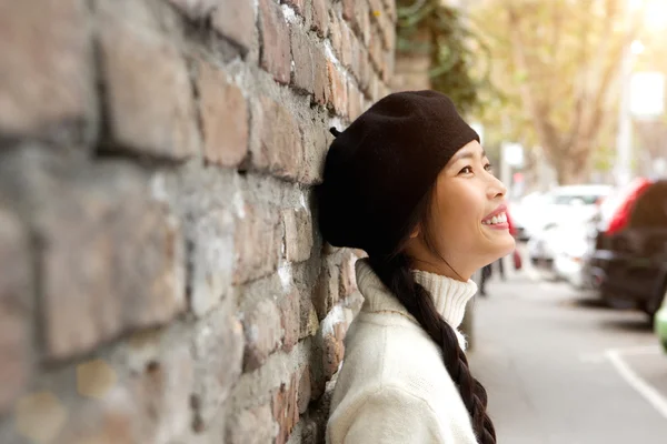 Happy young woman standing outside with beret
