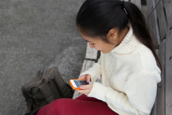 Young woman sending text message on mobile phone