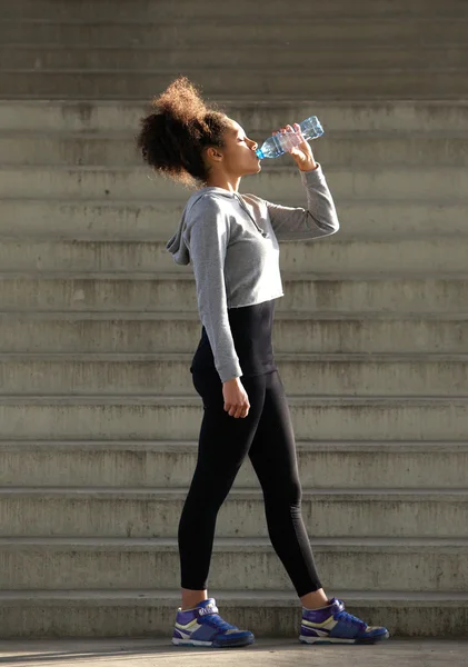 Female runner drinking from water bottle