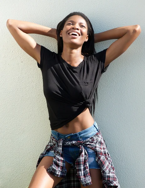 Young african woman smiling with hands behind head