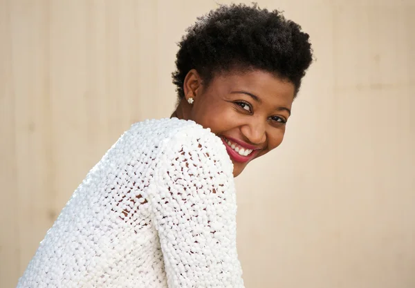 Happy young black woman smiling in white sweater