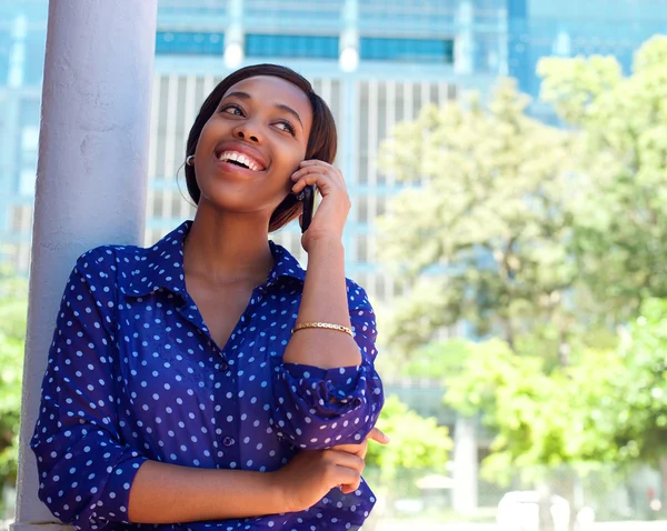 Happy young black woman calling by mobile phone