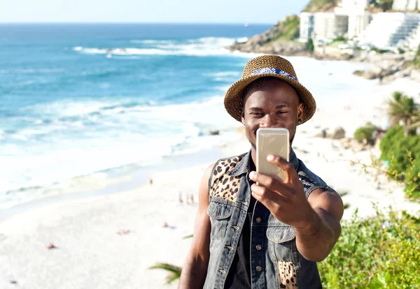 Happy african american man on vacation taking selfie