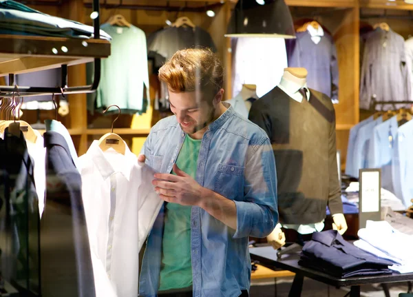 Happy man shopping for clothes at clothing store