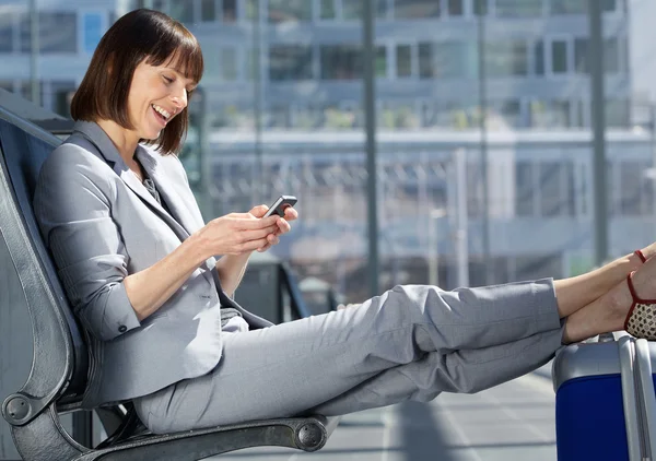 Traveling business woman smiling with mobile phone