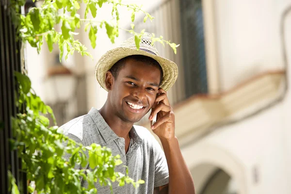 Happy guy calling with mobile phone outside