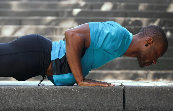 African american man sport training workout push ups outside