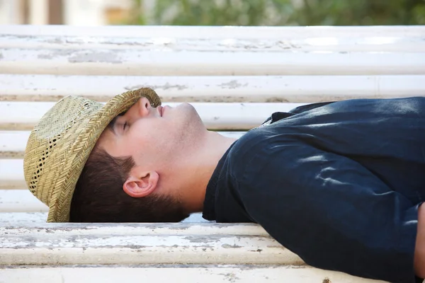 Man sleeping on park bench outside