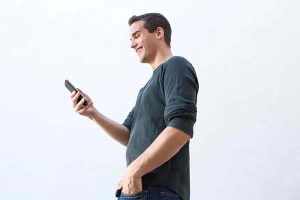 Smiling man walking and looking at mobile phone