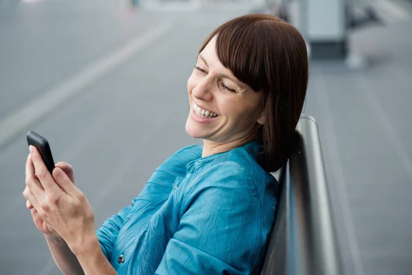 Beautiful middle aged woman looking at cell phone