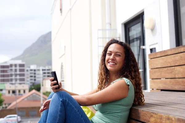 Young woman smiling with mobile phone in the city