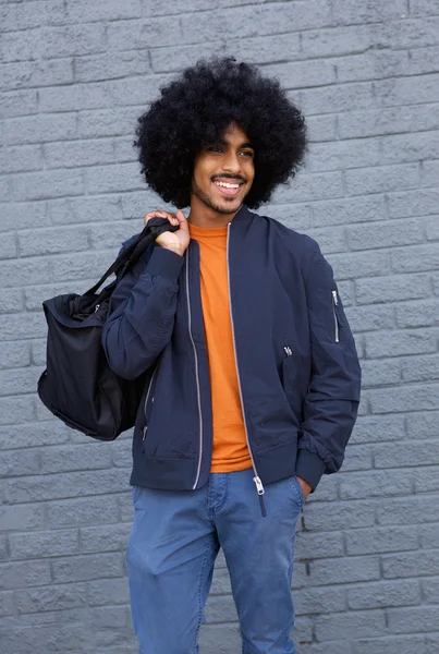 Cool male fashion model with afro and bag