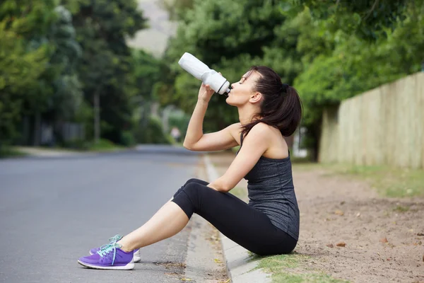 Fit young lady drinking water