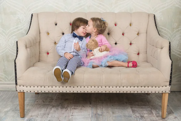 Toddlers love.  Boy and girl sitting on the couch. Valentine\'s D