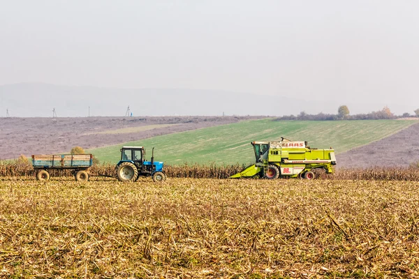 Tractor and harvester in autumn field