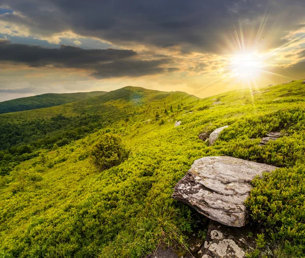 Stones in valley on top of mountain range at sunset