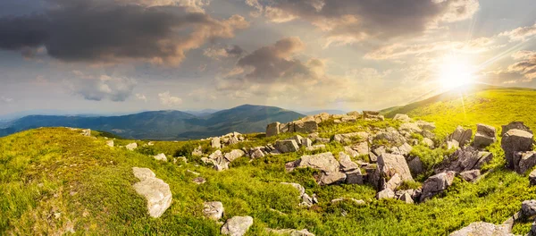 Stones in valley on top of mountain range at sunset