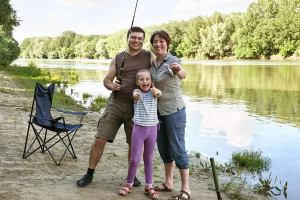 People camping and fishing, family active in nature, fish caught on bait, river and forest, summer season