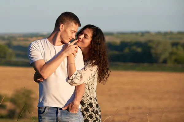 Happy young couple posing high on country outdoor over yellow field, romantic people concept, summer season