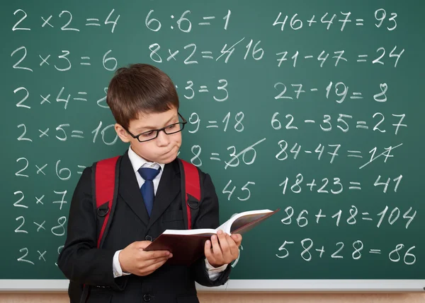 School boy exercise math on board