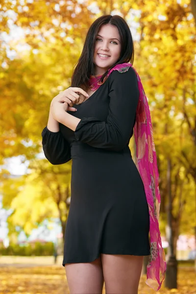 Beautiful girl in black dress in yellow city park, fall season