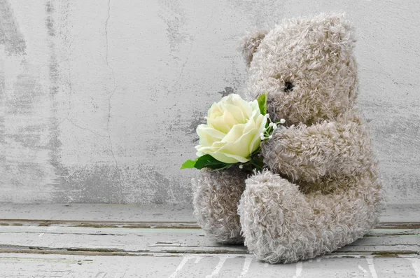 Cute bear doll holding rose bouquet