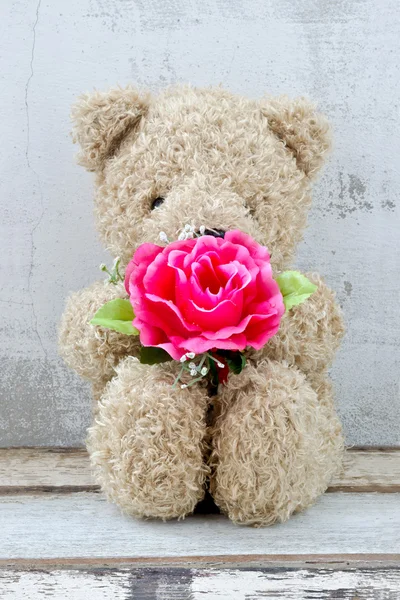 Cute bear doll holding rose bouquet