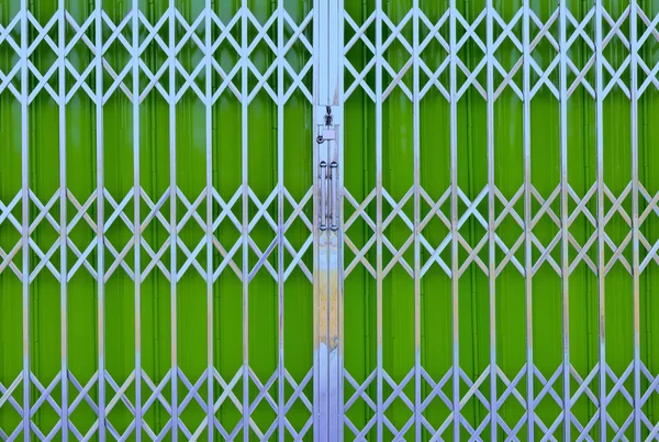 Green metal grille sliding door with pad lock and aluminum handl