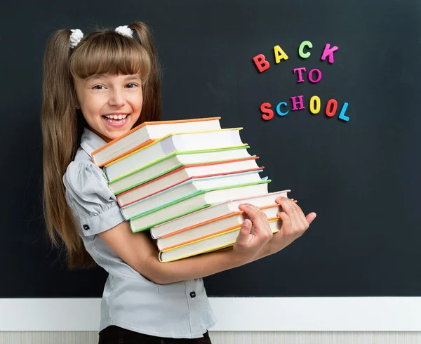 Girl with books at the chalkboard