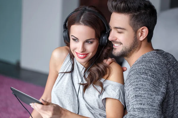 Happy young couple listening music indoor