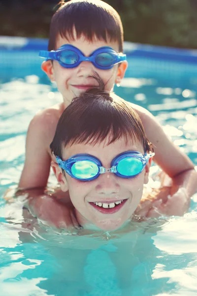 Happy little brothers in goggles swim