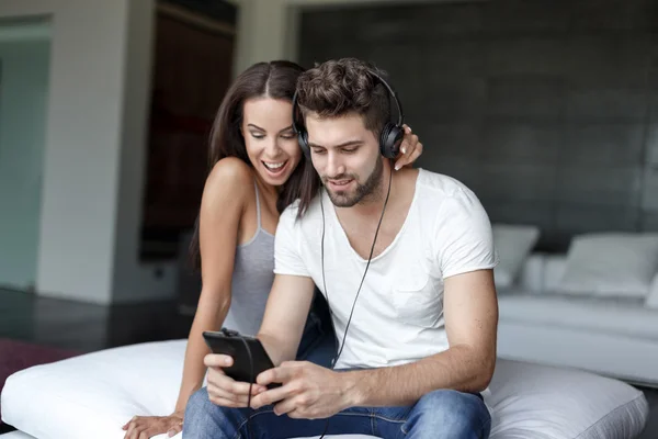 Casual caucasian couple listening music on tablet