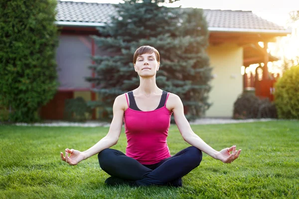 Fit woman in sportswear practice yoga outdoor