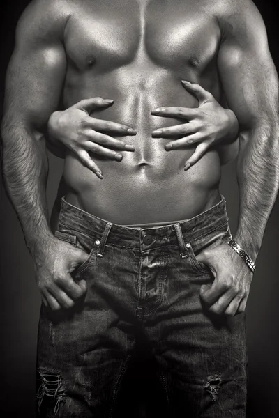 Woman hands embracing sexy man abs black and white