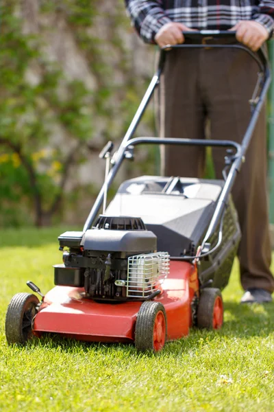 Senior man mowing grass