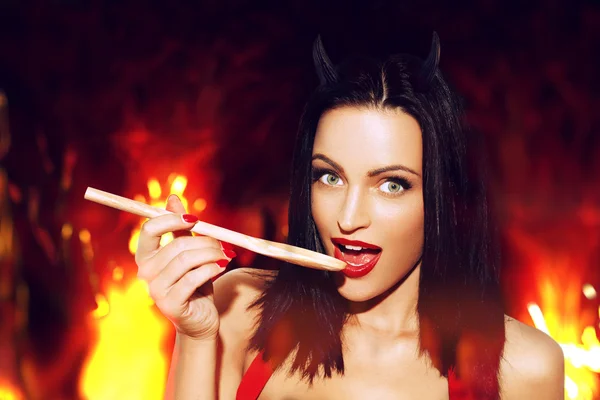 Sexy woman with red lips taste meal in hell