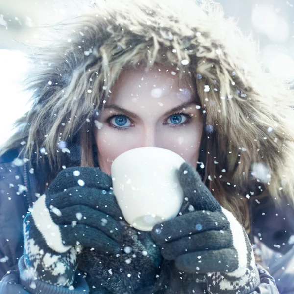 Winter woman drink from white mug