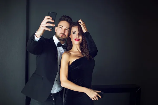 Fashionable rich celebrity couple taking selfie