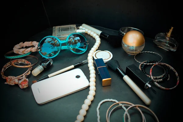 Female accessories and cosmetics on a black background