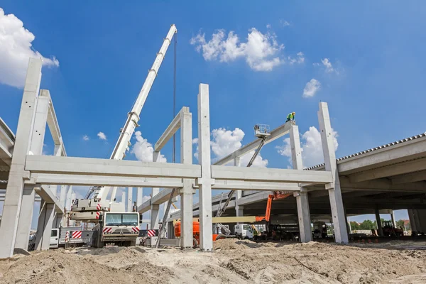 Mobile crane is carry concrete joist to assembly huge hall.