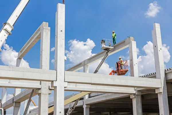 Mobile crane is carry concrete joist to assembly huge hall.