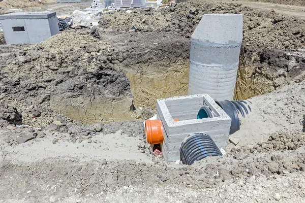 Concrete drainage manhole is unfinished on building site.
