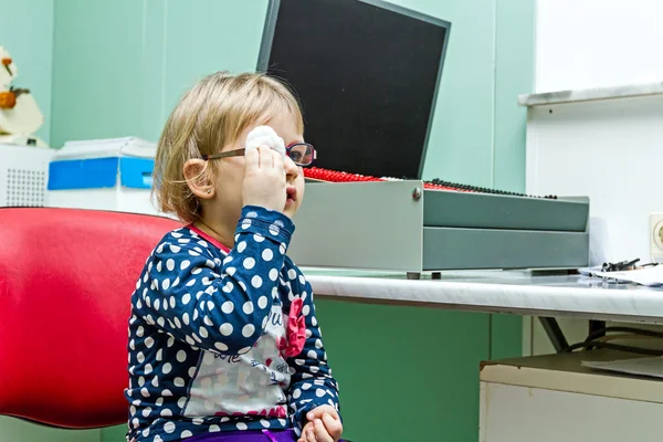 Eye exam, cute little girl is reviewing eyesight.
