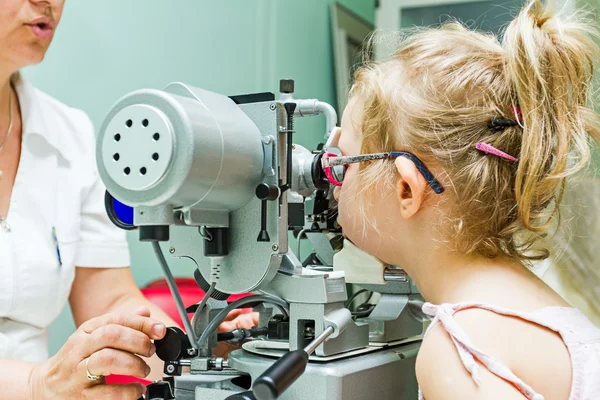 Optometrist with patient, giving an eye examination