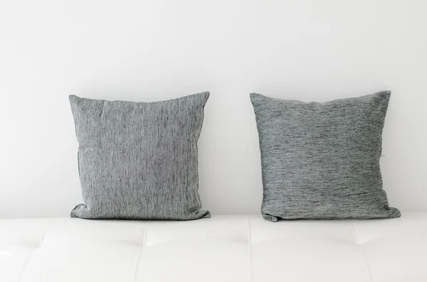 Black decorative pillows on a white casual sofa in the living ro