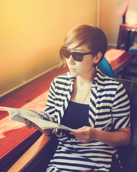 Smart short hair woman wearing sun glasses sitting in the cafe r