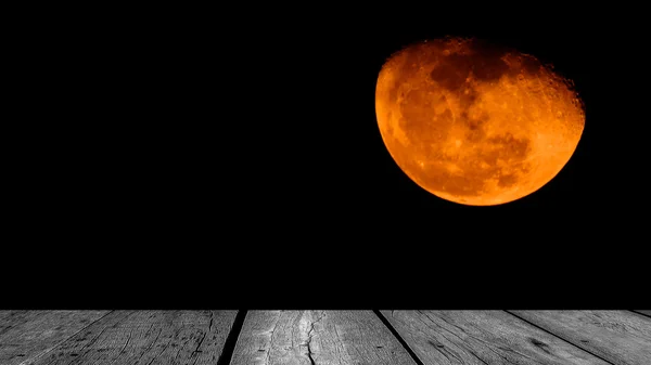 Orange moon with black and white wooden floor.