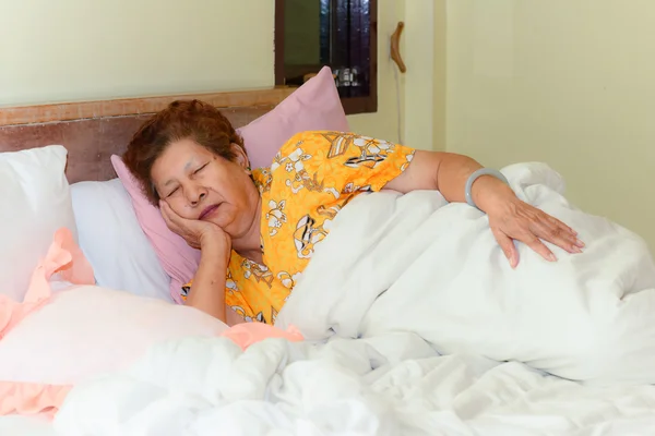 Asian Senior Woman lying in bed sleeping