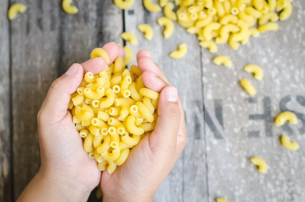 Italian Macaroni Pasta  in child hand.