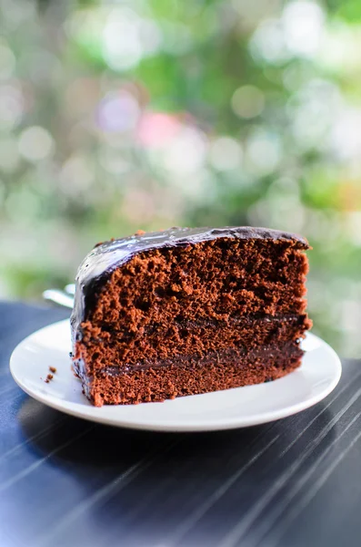 Slice Dark chocolate cake with bokeh background.